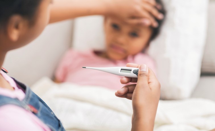 Mother checks temperature of her daughter.