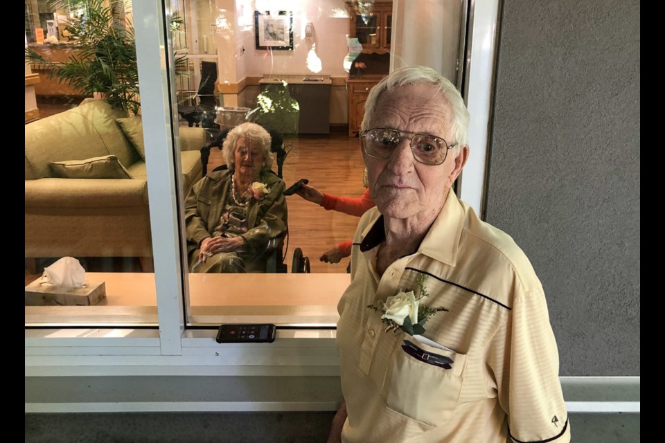 Bill and Mary Bell celebrated their 70th anniversary with strict COVID-19 protocols as she is in Dufferin Care Centre and he lives independently at home. The Coquitlam couple's family waved through a window from outside while Bill was allowed to go in for a visit.