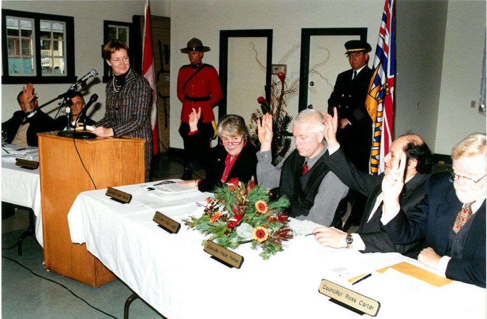 Councillors sitting down with their hands raised –– inside the old general store