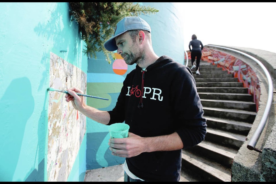 Luke Ramsey works on a mural at the bottom of the spiral staircase off Dallas Road in 2017. ADRIAN LAM, TIMES COLONIST