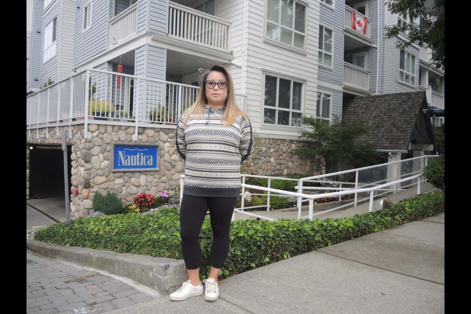 Sara Chung, outside her Steveston condo building. Her apartment is still not habitable, 14 months after a fireplace gas explosion in the unit above. Alan Campbell photo