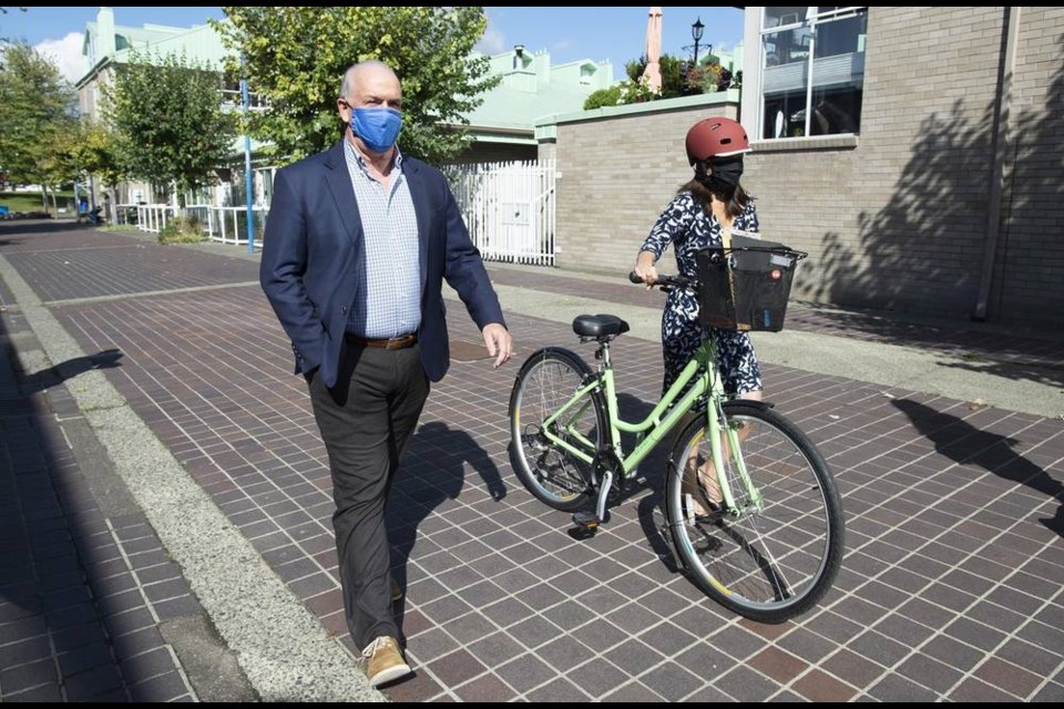 NDP Leader John Horgan walks with local candidate Bowinn Ma after making an announcement during a election campaign stop in North Vancouver, Tuesday, September 22, 2020. THE CANADIAN PRESS/Jonathan Hayward