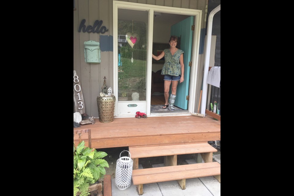 WARM WELCOME: Painting her front door blue is just a small part of Joan Fitzpatrick’s most recent house renovation project, the second she has undertaken since moving to Powell River from Ontario. Joyce Carlson photo