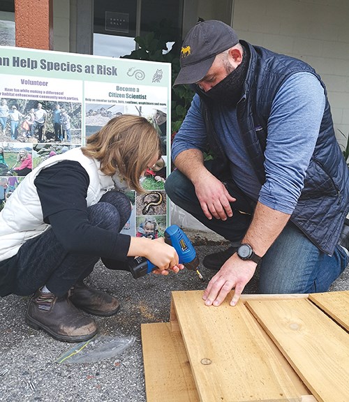 Putting together a bat house during a workshop for Woodcreek Park residents.