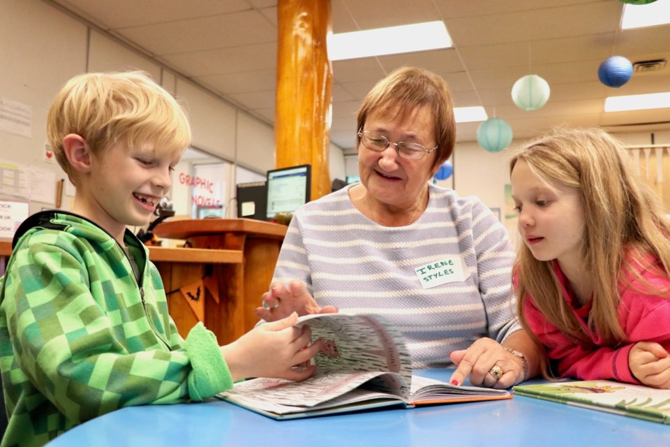 Two BICS children and a grand friend reading a book