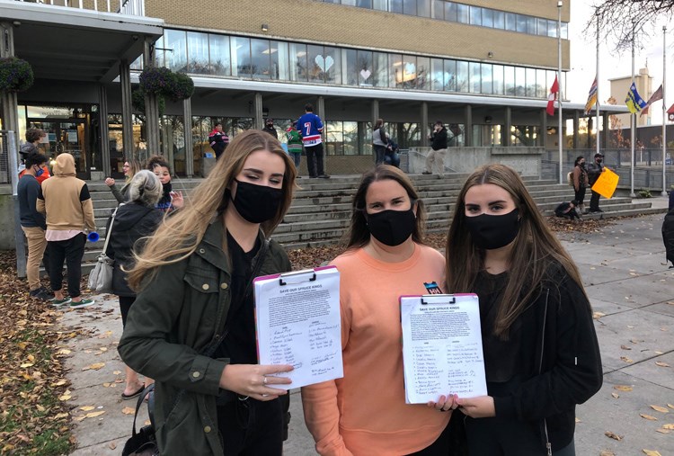 Bonnie Schnepf, centre, and her daughters Tianna (left) and Anataya (right) Schnepf display copies of the petition they organized calling for city council to reopen Rolling Mix Concrete Arena. The Schnepfs organized a rally outside city hall prior to the issue going before city council on Monday night.