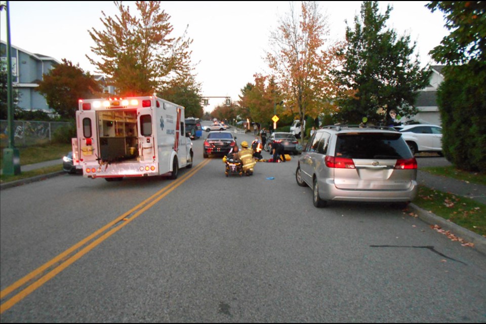 Paramedics, firefighters and police treat the victims of a collision involving two pedestrians on Pinetree Way near Tantalus Court, Coquitlam