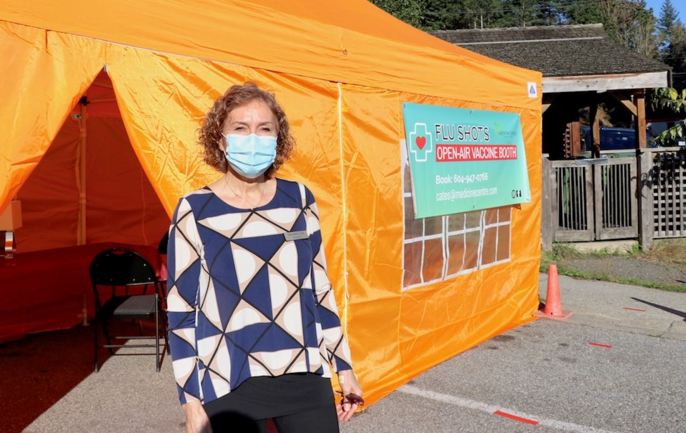 Woman in a mask standing in front of a big orange tent