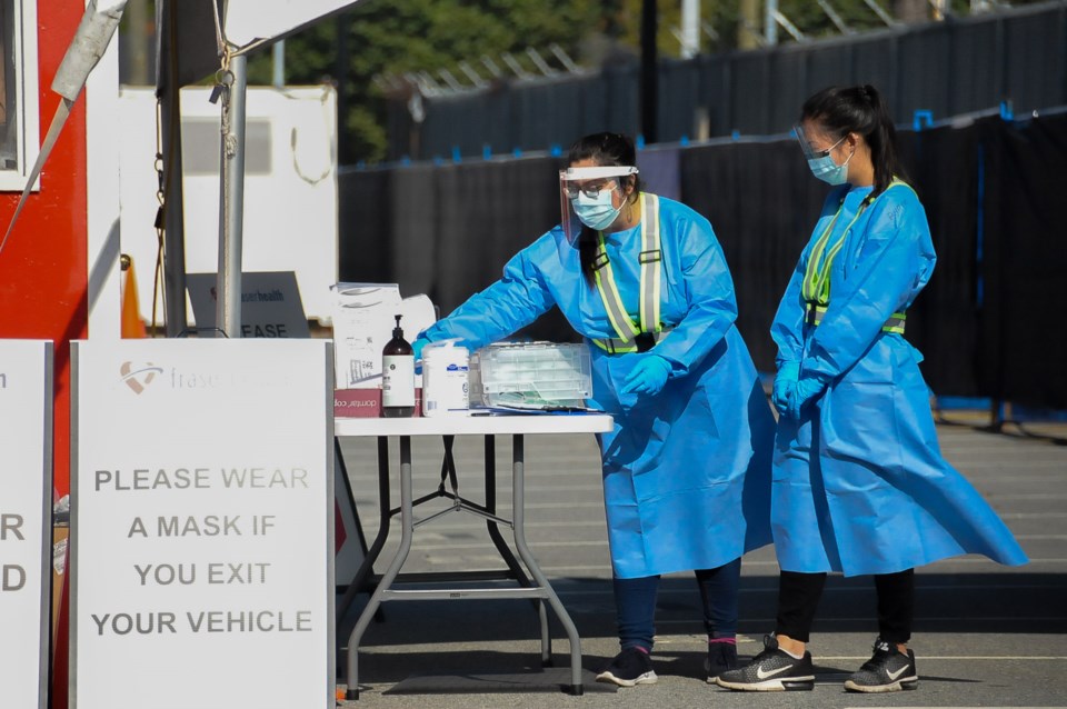 Fraser Health staff wait to greet people at a drive-thru testing site newly opened in Coquitlam this