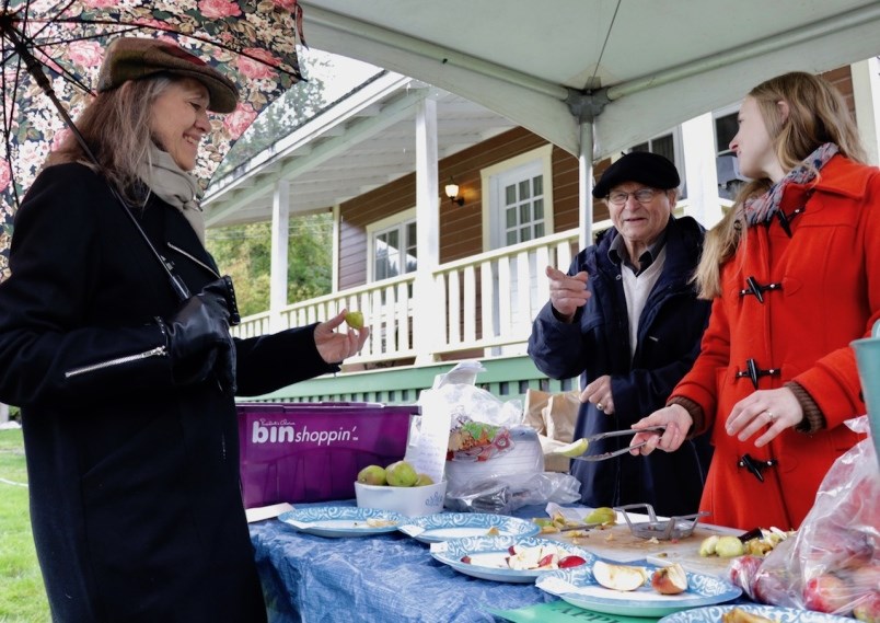 Carol Shatford tastes some of the apples HC Behm and Marysia McGilvray had out at Applefest 2018.