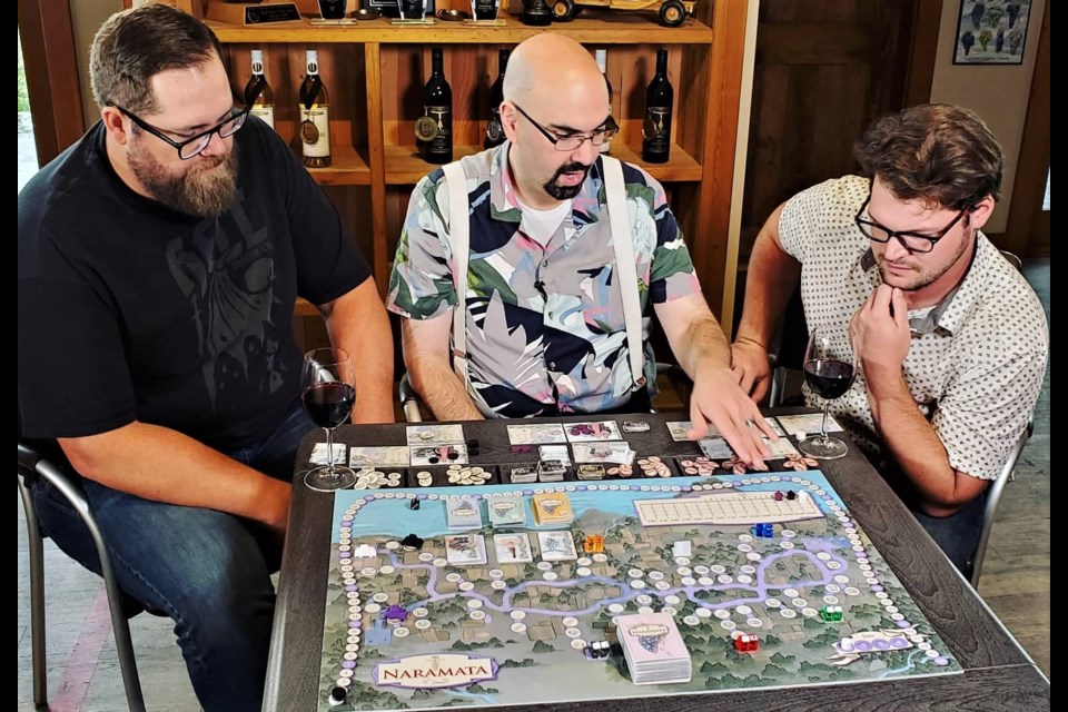 Chris Dias, centre, plays a prototype version of Naramata: A Game of Wine and Tourism, with Will Hardman, left, and Paul Rhodenize of Deep Roots Winery in Naramata.