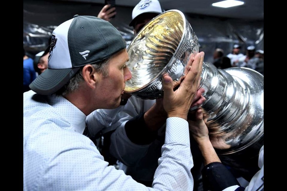 Tampa Bay Lightning head coach Jon Cooper takes a sip of champagne from the Stanley Cup in the Lightning dressing room at Rogers Place in Edmonton. The pandemic means Cooper likely won't be bringing the cup home to Prince George this year.