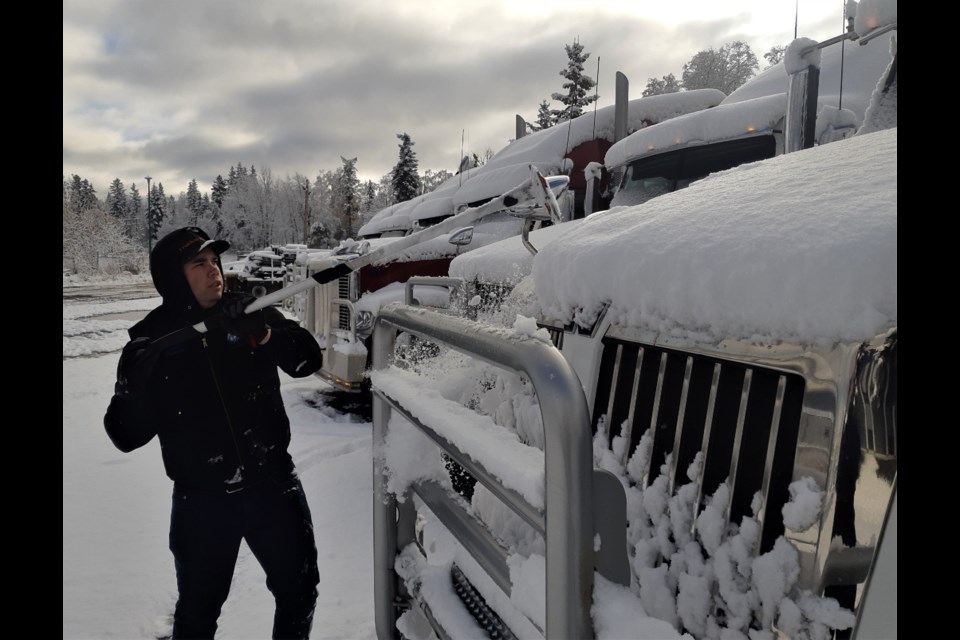 James Christie clears snow off the trucks parked in the company's lot on Fourth Avenue Monday morning. The unseasonable cold weather is expected to continue all week, with record-breaking low temperatures forecast late this week.