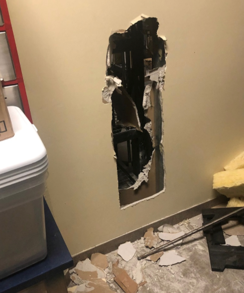 A wall smashed in to gain entrance.