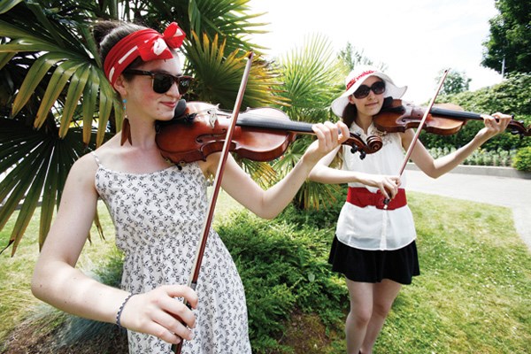 Sara Dal Santo and Cara Jacobsen play violin for the crowds.