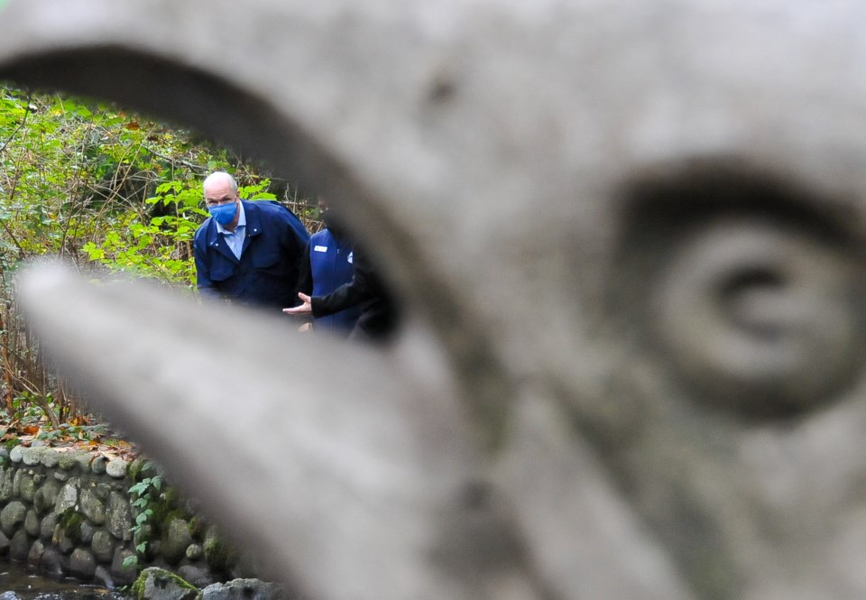 BC NDP Leader John Horgan seen through a statue of a salmon during a visit to Hoy Creek Hatchery in