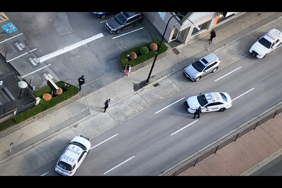 Burnaby RCMP officers surround a woman who had been walking down a Metrotown sidewalk with a large steak knife in hand Wednesday. The woman was apprehended under the Mental Health Act. The incident was captured in a video posted on YouTube.