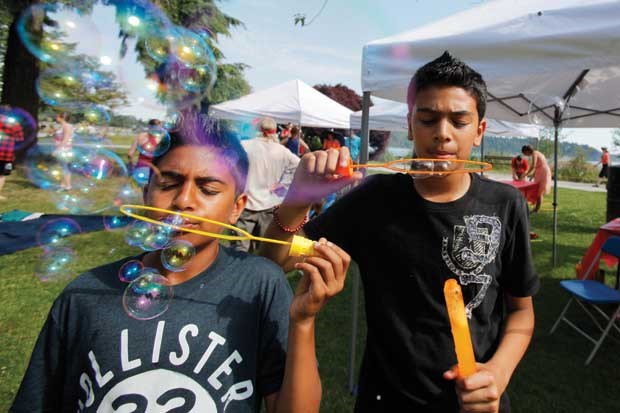 Ayden, 11 and Tarig, 11 blow bubbles