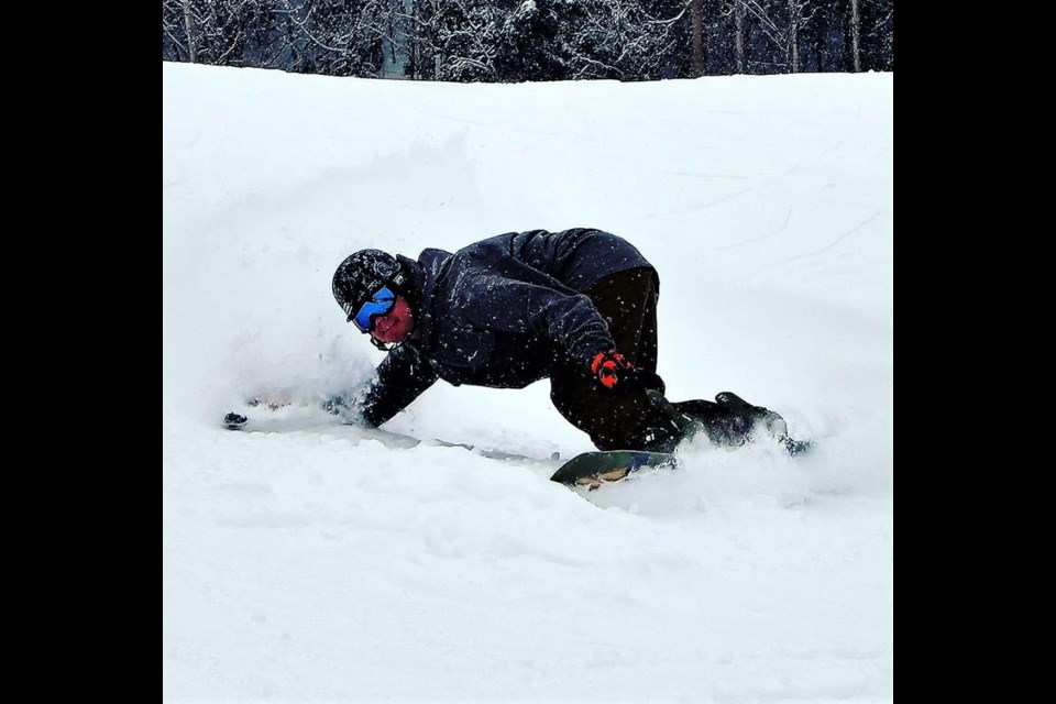 Kyle Rowell goes low to cut a corner on his snowboard last season on the Hart Ski Hill. Rowell won't have long to wait to go sliding again if the unseasonably cool and snowy conditions persist in the city.