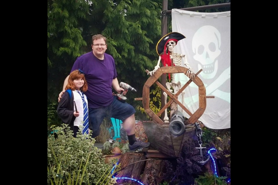 Michael Thomas, shown here with his daughter, built a large Pirates of Caribbean display at his house at 4058 Liverpool Street, complete with projected images, scary sounds and booming cannons.