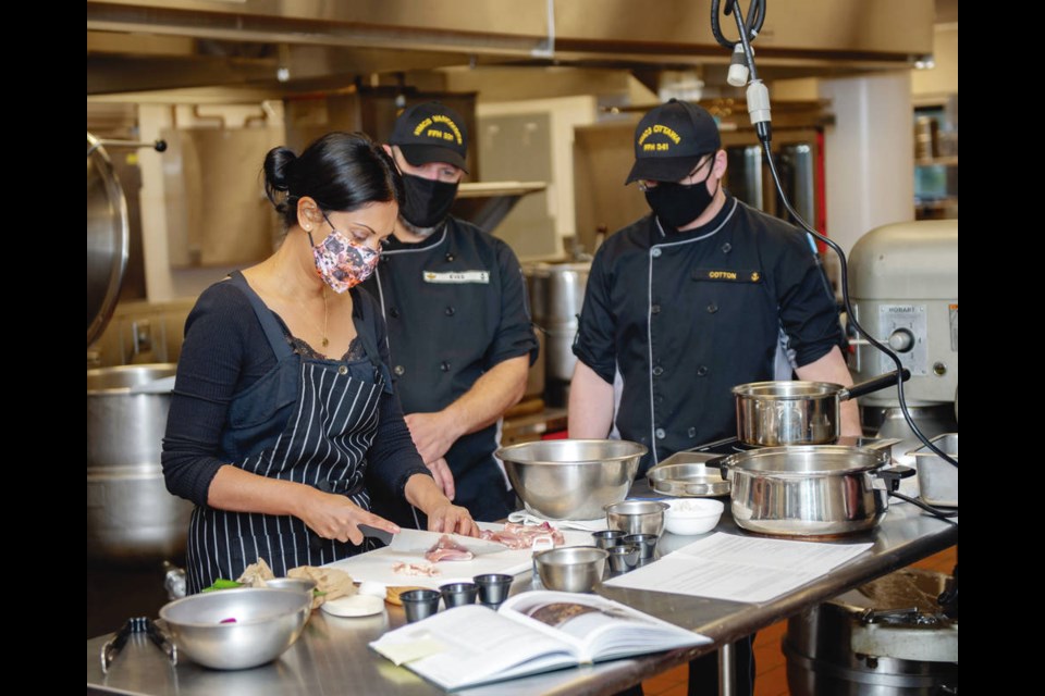 Chef Ruwan Samarakoon-Amunugama, left, cuts chicken and other ingredients for her chicken curry as cooks from HMCS Vancouver, centre, and HMCS Ottawa, right looks on in the galley of CFB Esquimalt. Samarakoon-Amunugama was a guest during Food Diversity Week (Oct. 26 to 30) at the base.   Sailor First Class Mike Goluboff