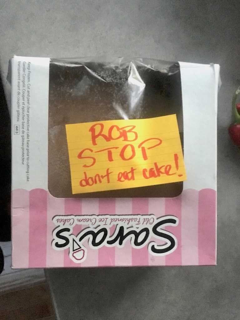 A cake box with a note reading 'Rob stop don't eat cake!'