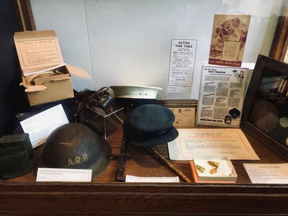 Military caps amid other military artefacts and information