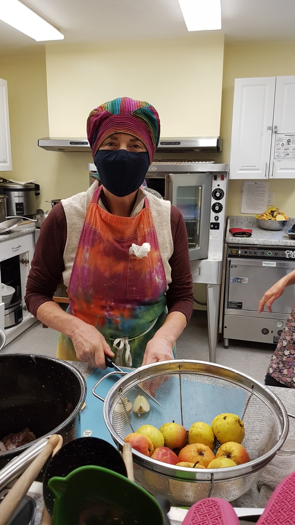 BIFS member Susan Swift peels and chops apples in an industrial kitchen