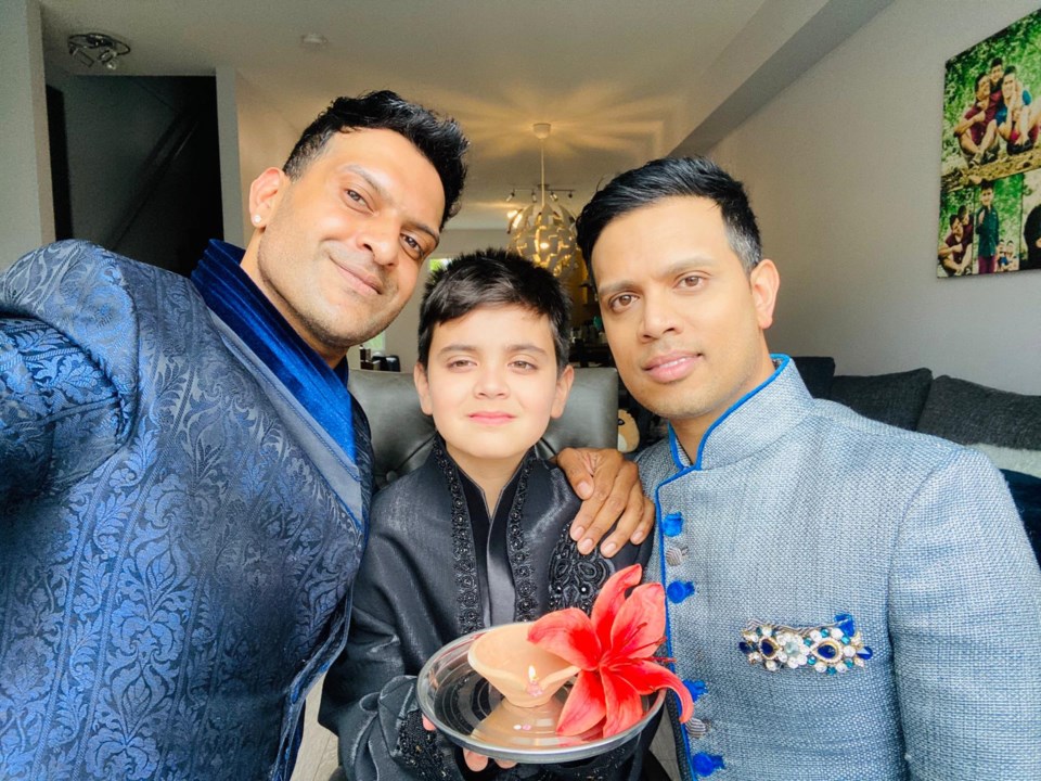 Irshad Abdulla and Vishad Deeplaul pose for a photo with their son Zrav during Diwali, the Hindu cel