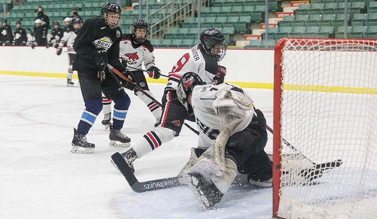 Citizen Photo by James Doyle/Local Journalism Initiative. North Central Bobcats forward Tristan Granter makes a nifty move to tuck the puck into the net past the stretched out North Zone Kings goaltender on Saturday afternoon at CN Centre.