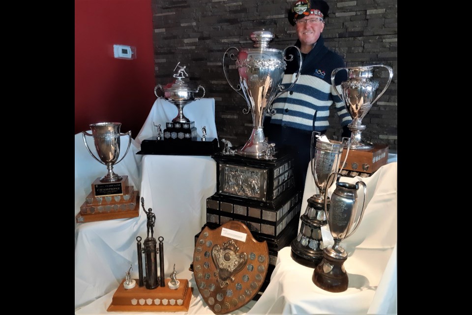 Don McDermid, general manager of the Prince George Golf and Curling Club, shows off some of the many trophies the club has presented to curling teams in its 100-year history. The centrepiece is the 42-inch tall Kelly Cup, curling's largest trophy, the big prize in the club's annual men's bonspiel.