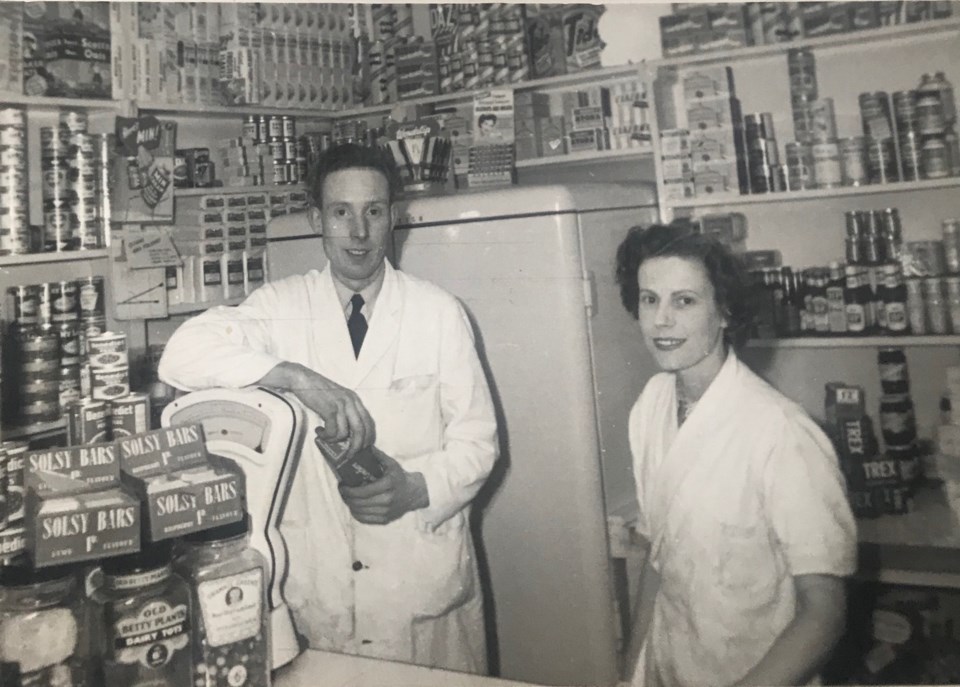 Two people standing at grocery counter - black and white photo