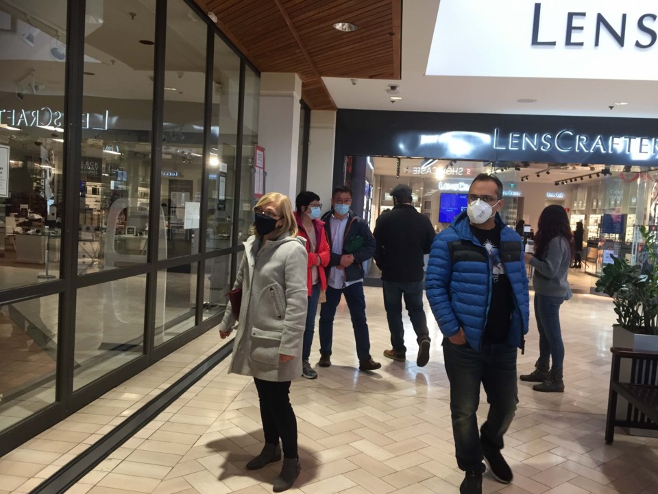 Shoppers peer into the Hudson's Bay at Coquitlam Centre after it was shuttered for failing to pay re