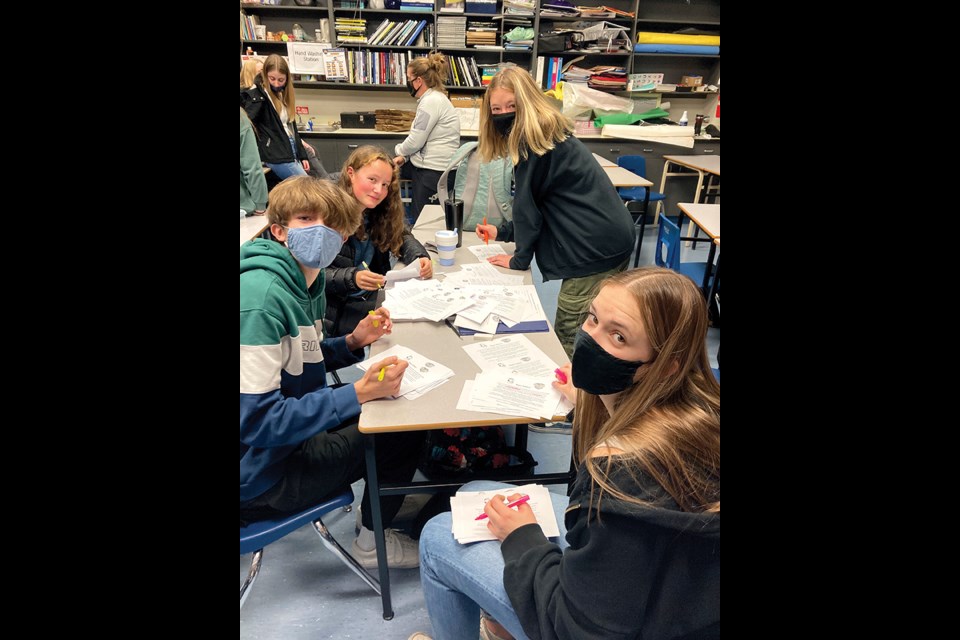 Elphinstone leadership classmates Theo Barlow (front left), Koenn Sauer (front right), Katie Kennelly (back left) and Mika Kliewer (back right) prepare food drive labels.