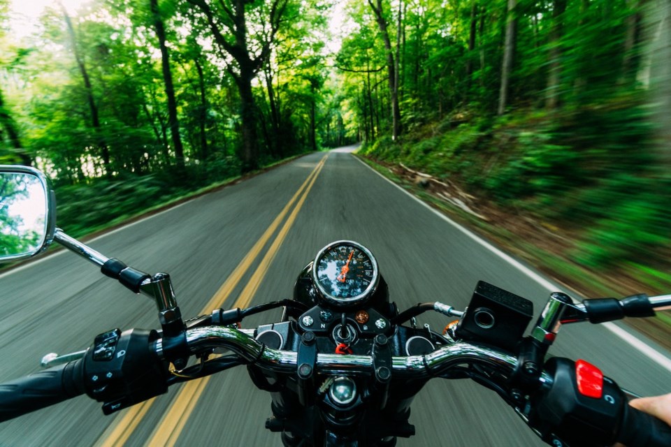 A bike of some sort on a roadway in the forest