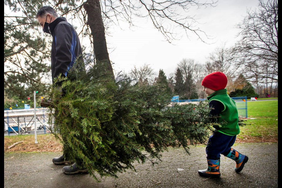 Three-year-old Vincent Lowes helps his grandfather Gary Edge carry the Christmas tree they picked out at the Vikes sale at UVic's Centennial Stadium on Thursday, Dec. 3, 2020.  DARREN STONE, TIMES COLONIST