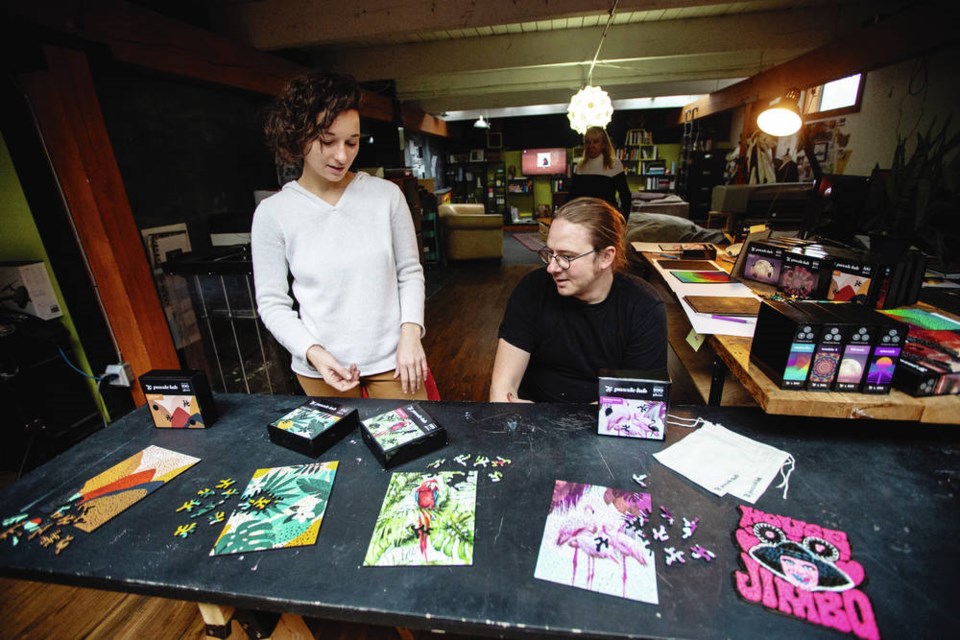 Tinka Robev and Andrew Azzopardi with their wooden jigsaw puzzles last fall. DARREN STONE, TIMES COLONIST