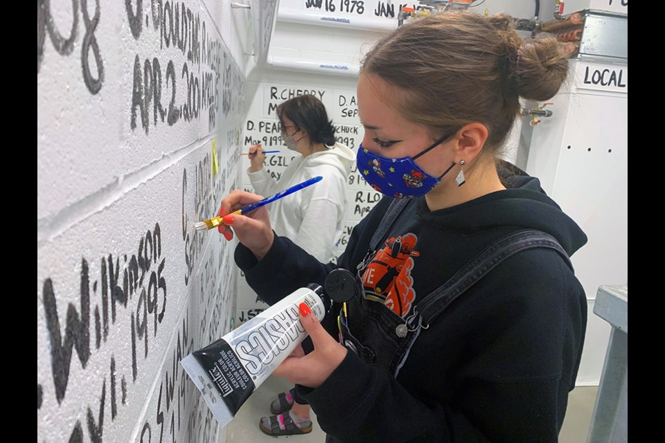 Duchess Park Grade 12 students Gabriella Vis, front, and Brenna Harasym do a few touchups on the hose tower wall at the City of Prince George's new Fire Hall No. 1 on Massey Drive. The Art Portfolio 12 students were part of the team of 11 local students who worked on the Fire Hall No. 1 project. Handout photo