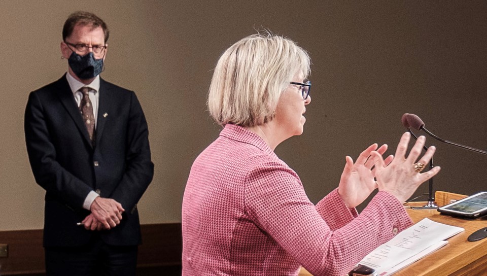 Health Minister Adrian Dix watches as provincial health officer Bonnie Henry addresses media
