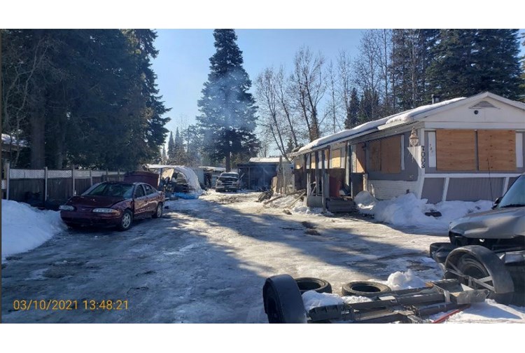 Derelict vehicles are seen in the yard of an abandoned mobile home at 7003 Adam Drive on March 10.