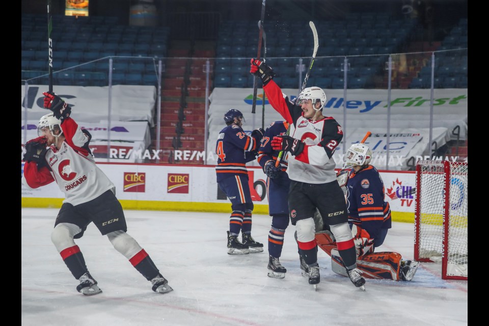 Cougars Connor Bowie, left, and Blake Eastman celebrate defenceman Ethan Samson's eventual game-winning goal, 9:01 into the second period, in what ended up a 5-1 victory over the Kamloops Blazers Wednesday night in the WHL hub in Kamloops.