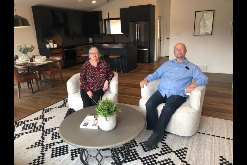 Pam and Daryl Berger take a load off after touring their new $670,000 home in the Aberdeen Glen subdivision. Pam's ticket was drawn as the grand prize winner Friday in the Spruce Kings Show Home Lottery.