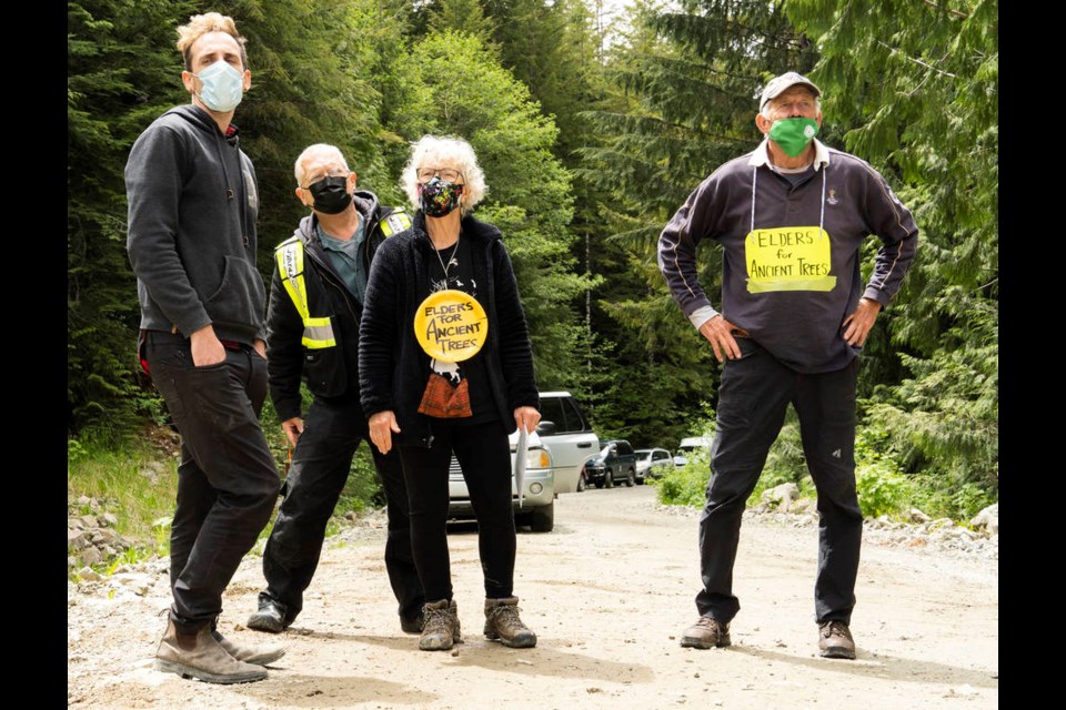 Seniors protesting the logging of old-growth forest gather in front of a RCMP checkpoint before marching up 2000 Block, near Port Renfrew B.C., on May 25, 2021.  (Norman Galimski/Photo)
