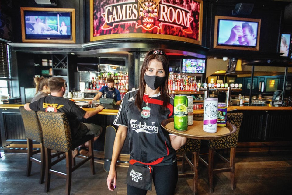 Robyn Grey serves drinks in the Games Room of the Sticky Wicket at the Strathcona Hotel, where liquor sales can now continue until midnight. DARREN STONE, TIMES COLONIST