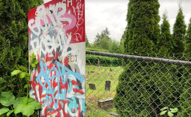 A sign at Squamish Nation’s North Vancouver cemetery with graves of residential school children asks for respect at the sacred site. It has been defaced