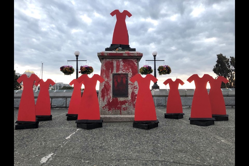 Wooden cutouts of red dresses, symbols of missing and murdered Indigenous women, were set up around where the Capt. James Cook statue used to stand. It was pulled down on Thursday, July 1, 2021. 
TIMES COLONIST