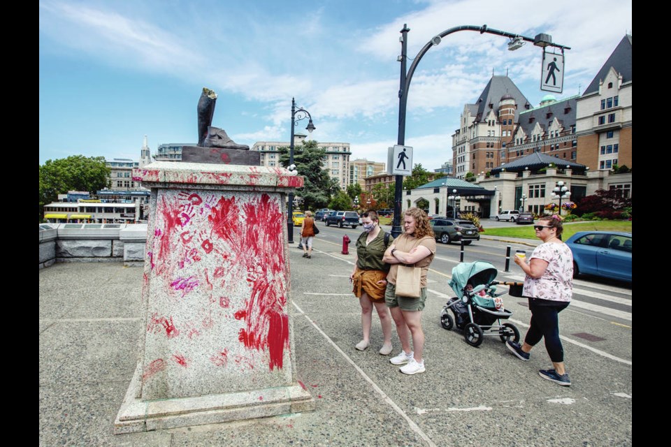 People check out whats left of the Captain James Cook statue, which was knocked over and tossed into the ­harbour on Canada Day. DARREN STONE, TIMES COLONIST