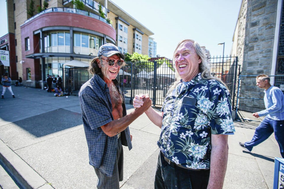 Rev. Al Tysick greets Sandy Fisher Ashe in front of Our Place Society on Monday, as he announces his retirement from the Dandelion Society. ADRIAN LAM, TIMES COLONIST
