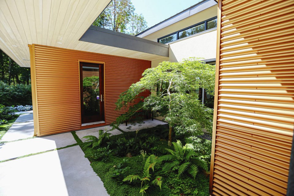 The front entrance of the Deep Cove home has gold galvanized steel siding inspired by the gold-barked arbutus tree in the backyard. ADRIAN LAM, TIMES COLONIST