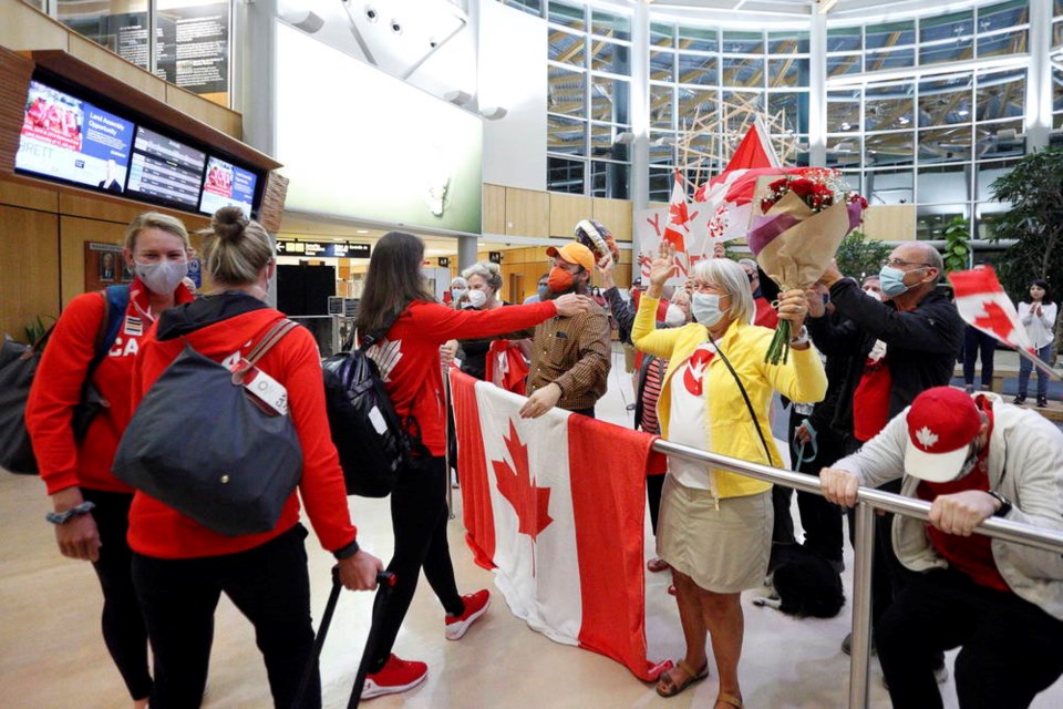 Christine Roper, Sydney Payne and Susanne Grainger, members of the women's eight rowing crew that captured the gold medal at the Tokyo Olympic Games, are greeted by family members at the Victoria International Airport on July 31, 2021. KEVIN LIGHT, ROWING CANADA